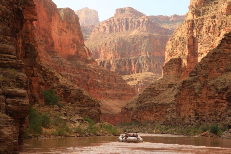 rafting en el grand canyon, montañas rojizas al fondo