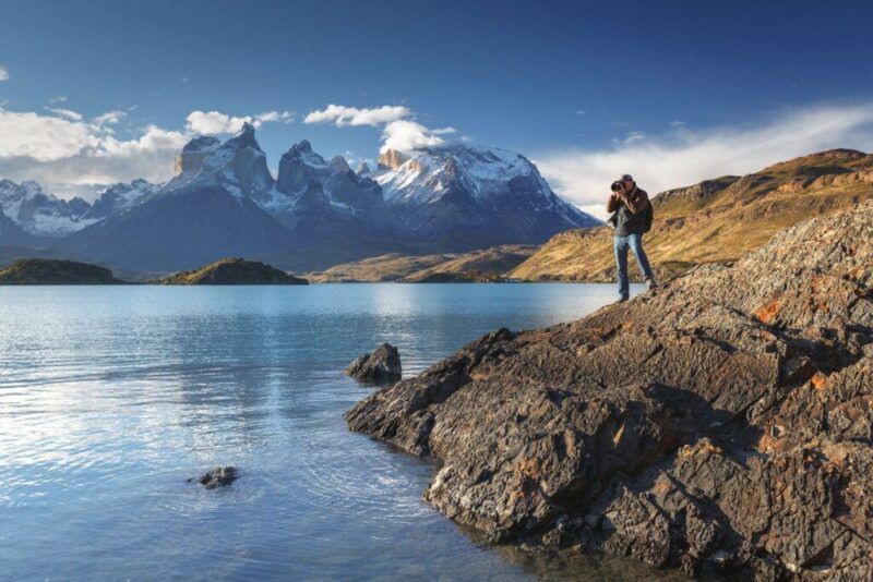 hombre sacando una foto encima de una roca en Torres del Paine, Cile