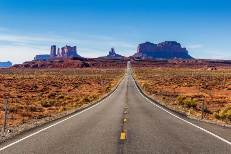 carretera en medio de paisaje natural seco en estados unidos, montañas al fondo