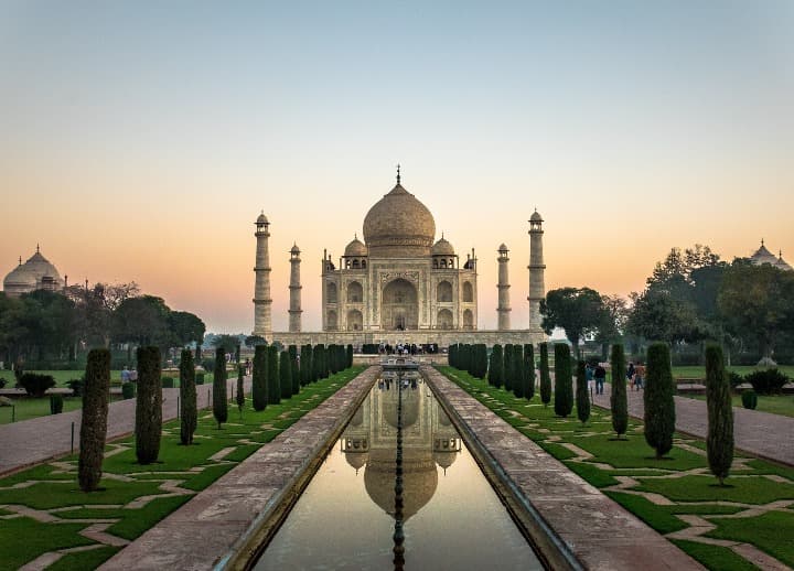edificio del taj mahal con delante fuentes de agua y árboles - weroad