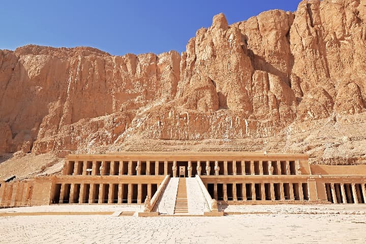 templo de luxor visto frontalmente, detrás montañas y cielo - weroad