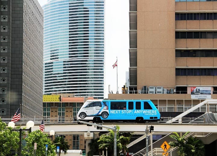 metromover, monorrail azul y blanco en medio de rascacielos - weroad