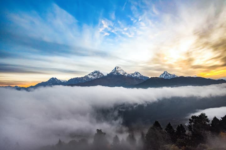 montañas al fondo en poon hill, sol que amanece detrás y nubes en primer plano - weroad