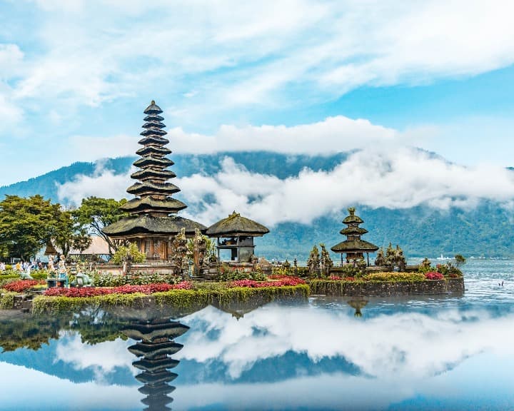 templo de pura ulun danu bratan reflejándose en el agua, detrás montañas y nubes