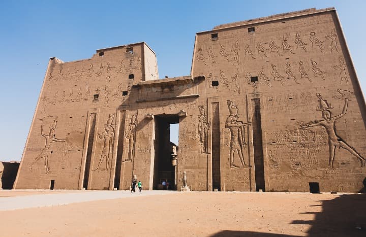 Templo de Edfu en Egipto, con sus enormes muros de piedra decorados con detallados jeroglíficos y relieves antiguos.