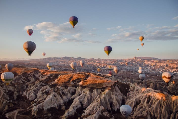 foto aerea del paisaje de goreme con globos aerostáticos volando en el cielo, algo que ver en turquia - weroad