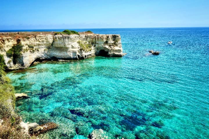 agua turquesa y espigón con acantilado al fondo en torre sant'andrea, lecce - weroad
