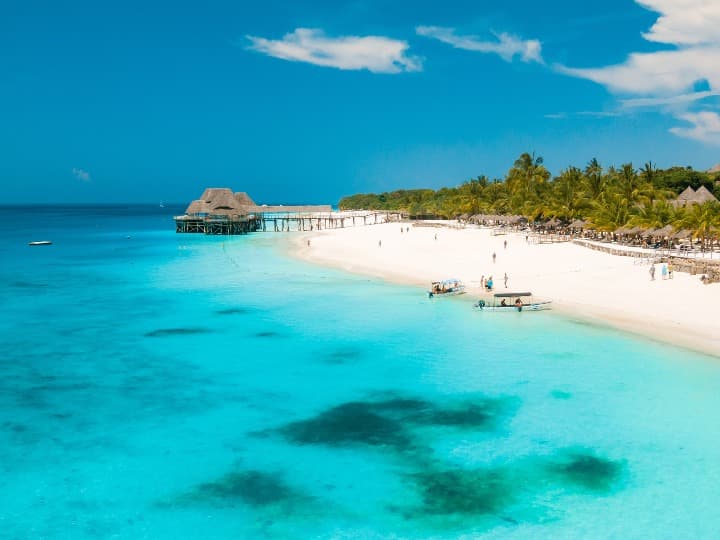 agua cristalina y playa detrás en zanzibar, destino ideal de vacaciones en agosto fuera de europa - weroad