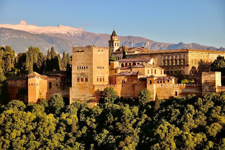 alhambra de granada, andalucia, rodeada de vegetación y montañas detrás - weroad