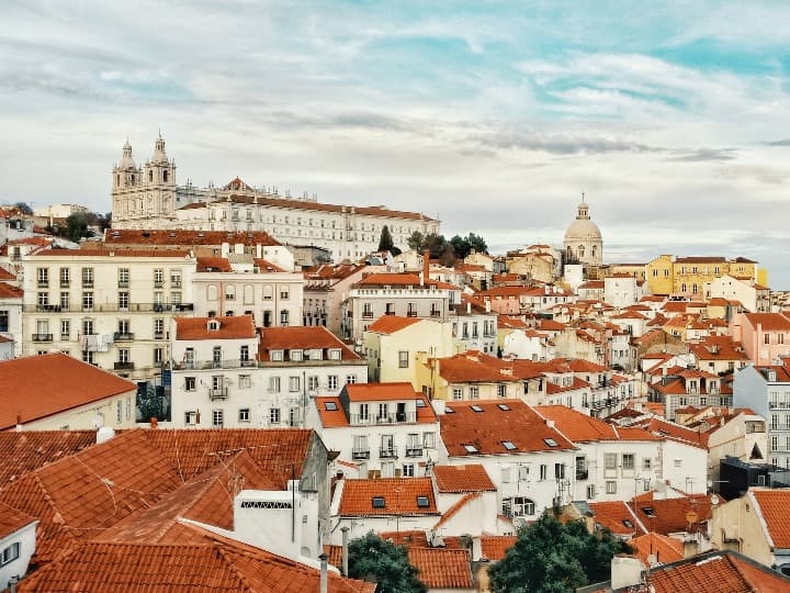 edificios y casas blancas con techos naranja de lisboa - weroad