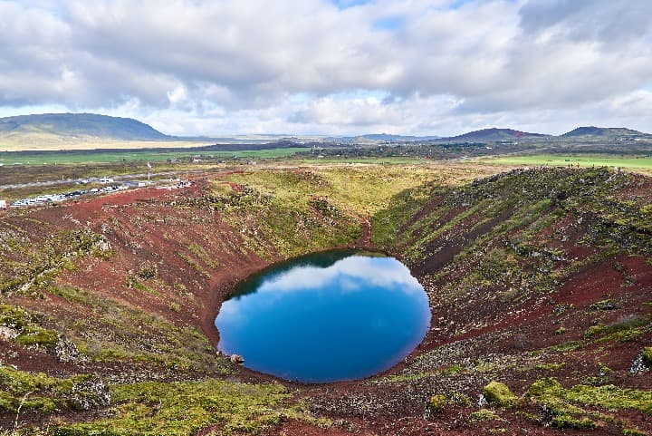 el creter kerid lleno de agua que refleja las nubes en el cielo - weroad