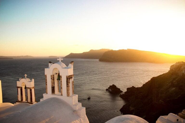 vista del mar de santorini desde el pueblo y los techos blancos de sus casas al atardecer - weroad