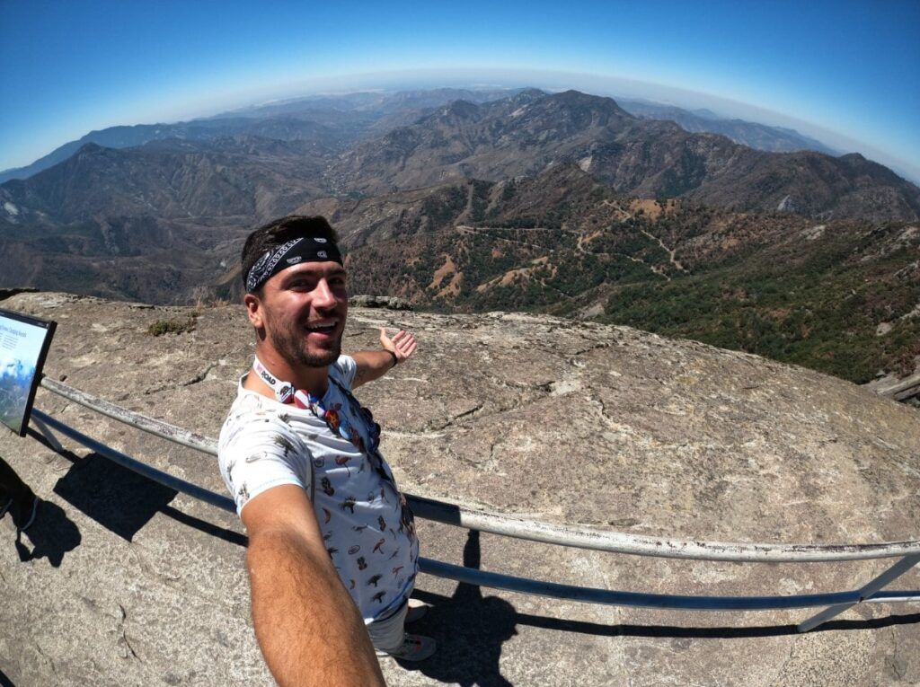 coordnador de weroad haciendo un selfie con dentrás paisaje montañoso en el yosemite national park