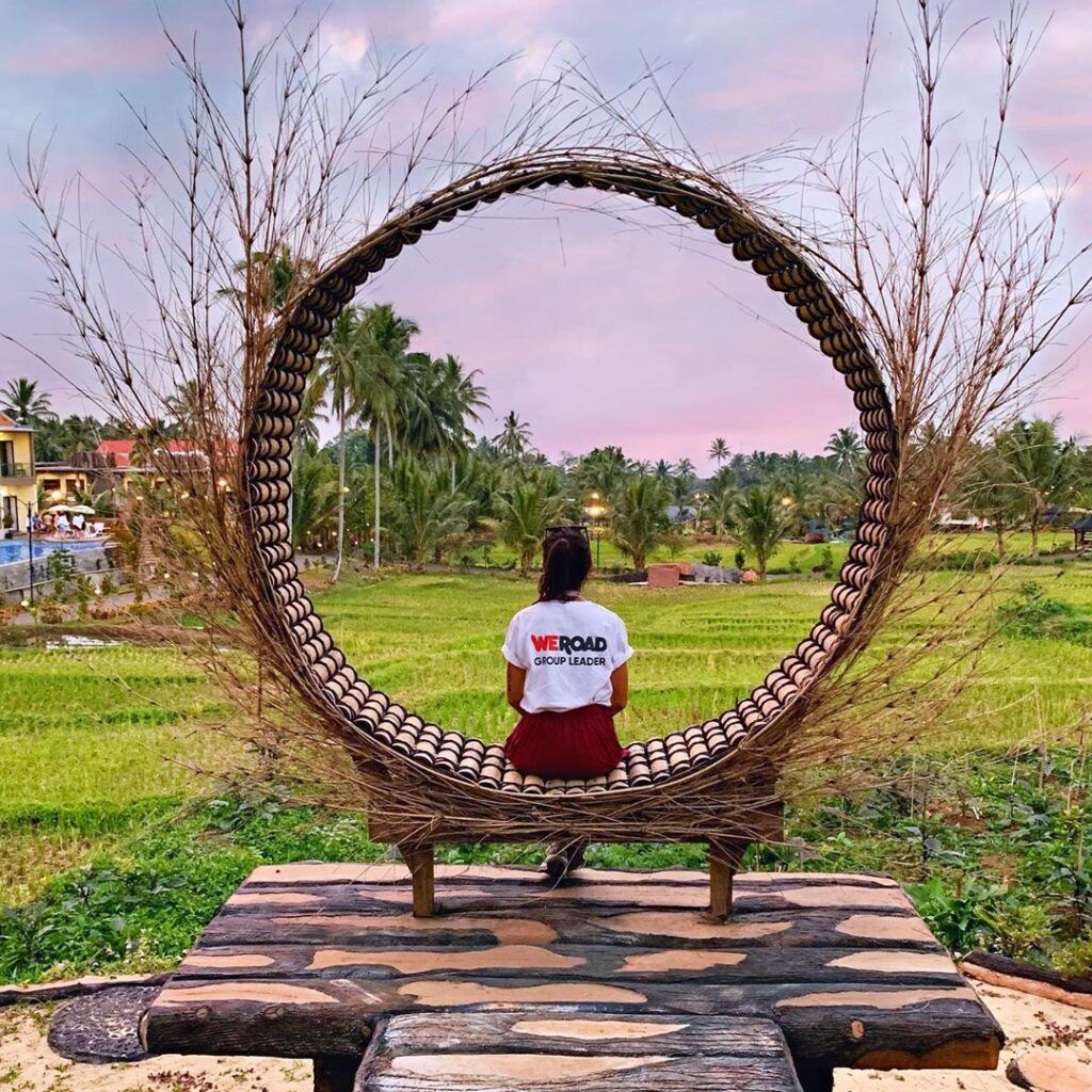 chica con camiseta de weroad sentada de espaldas en una silla con forma de aro