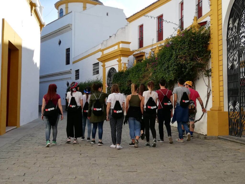 viajeros de weroad con su mochila de espaldas, caminando por las calles de sevilla