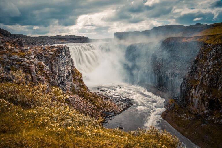 cascada de dettifoss en islandia, alrededor campos de hierba marrón - weroad