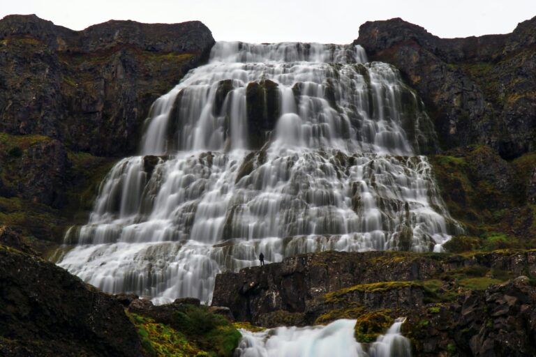 cascada de dynjandi vista desde abajo, detrás montaña marrón - weroad