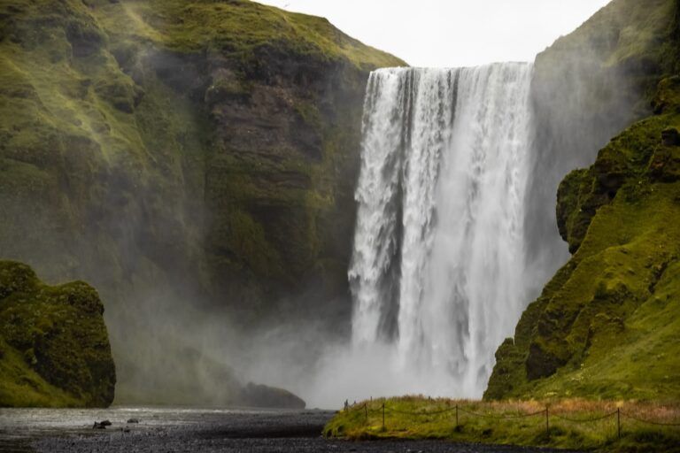 Cascada de skogafoss, detrás rocas verdes 