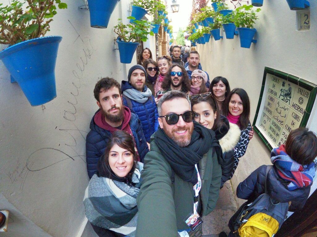 selfie de grupo de viajeros weroad en una calle de cordoba, andalucía, destino ideal para viajar en fin de año o en puentes 2025