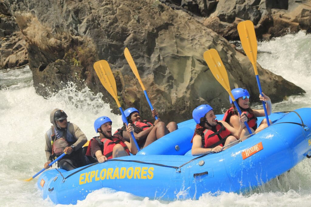 viajeros de weroad en un bote azul haciendo barranquismo en el parque nacional tortuguero en costa rica
