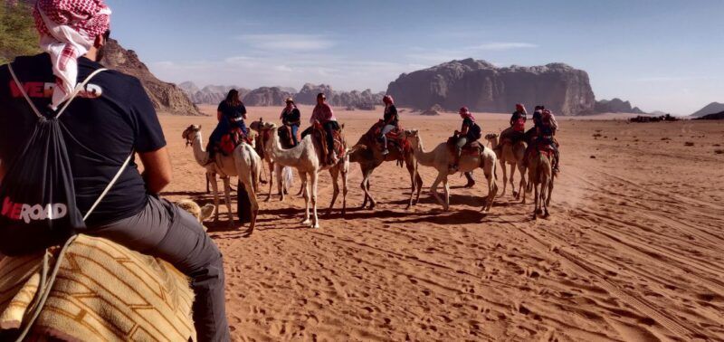 viajeros de weroad montados en camello en el desierto del wadi rum