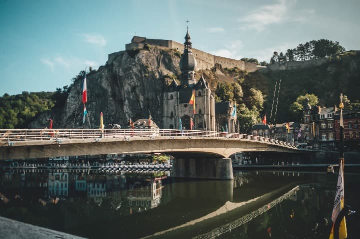 puente en dinant, al fondo iglésia y ladera de una montaña - weroad