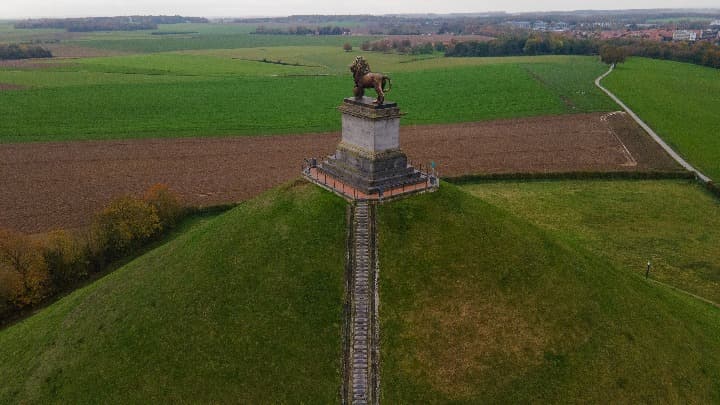 estatua de un león encima de una montaña verde artificial, lion's hill en waterloo, bélgica - weroad