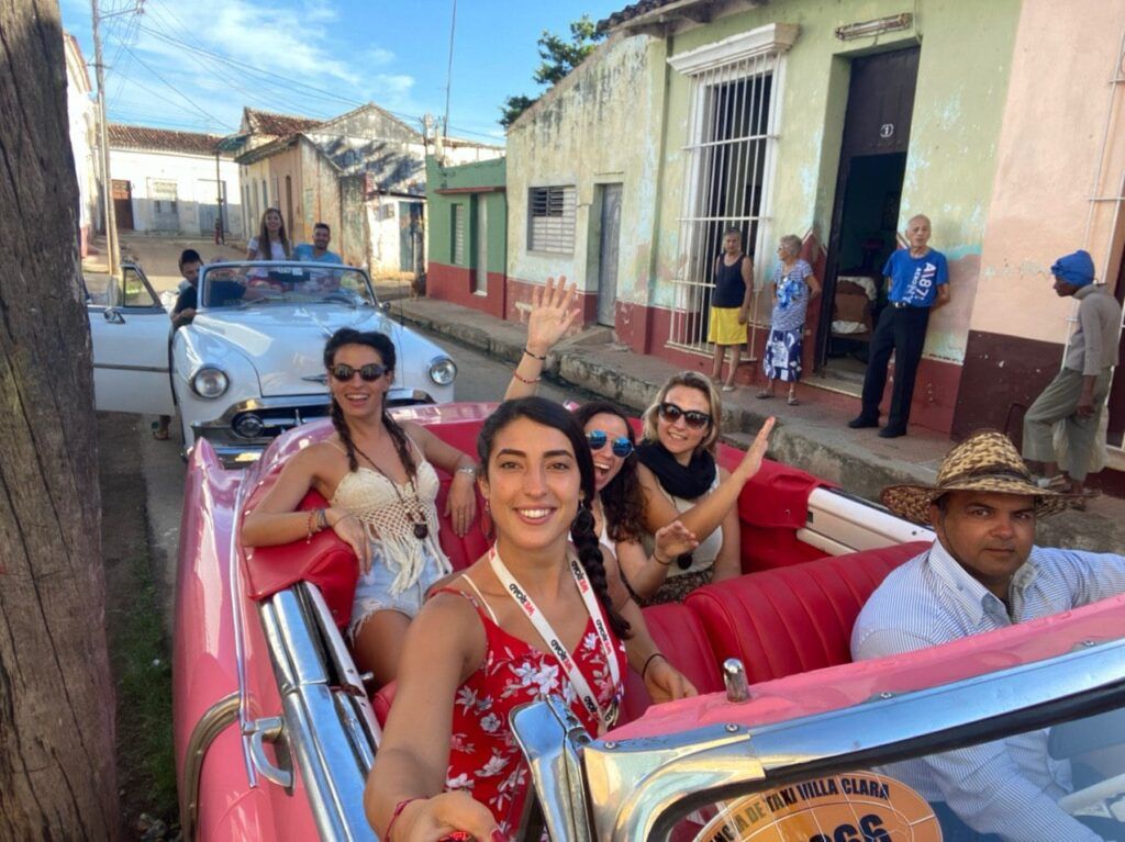Viajeros weroad haciedno un selfie en un coche antiguo en cuba.