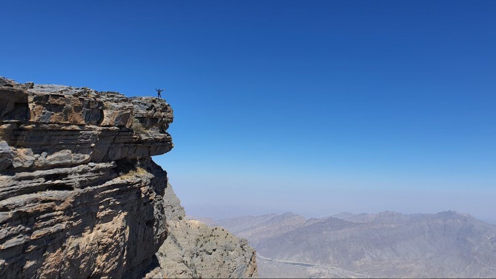persona en la punta de un precipicio, jebel shams, algo que ver en oman - weroad
