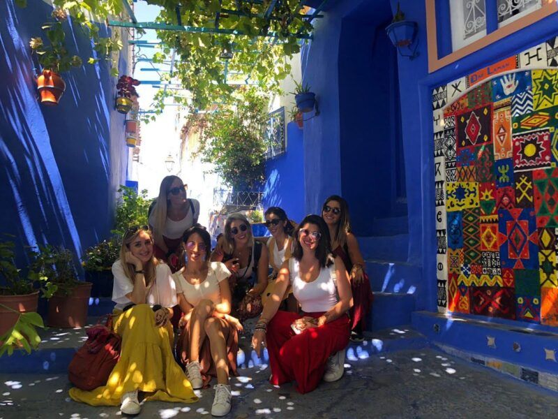 grupo de viajeros weroad en el jardin de una casa con paredes de color azul en marrakech