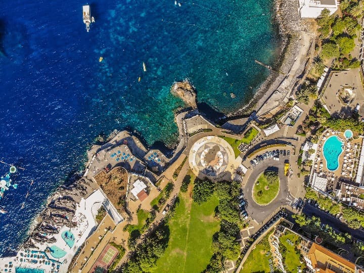 ciudad de funchal vista desde el cielo. se ven el mar, piscinas, campos verdes y carreteras - weroad