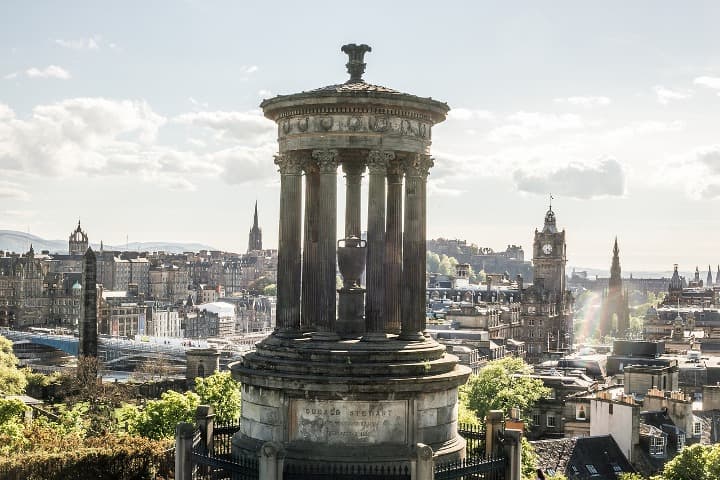 monumento con columnas en calton hill, algo que ver en edimburgo, al fondo la ciudad - weroad