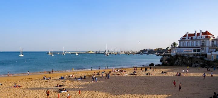 playa de cascais en porgugal, personas y edificio en la orilla - weroad