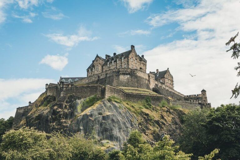 castillo de edimburgo encima de una colina, cielo azul detrás - weroad