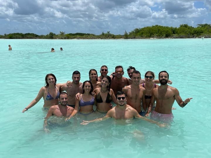 grupo de viajeros weroad en el agua turquesa de una playa de méxico