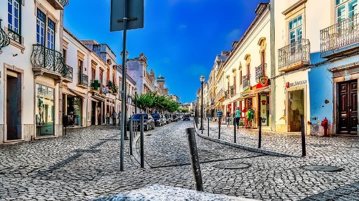 calles adoquinadas y edificios bajos en tavira, en algarve - weroad