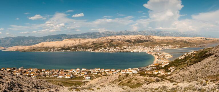playa de zrce, montañas al fondo y cielo - weroad