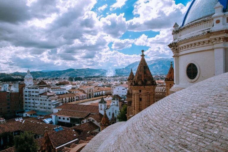 techos de edificios e iglesia en cuenca, en ecuador, cielo con nubes - weroad