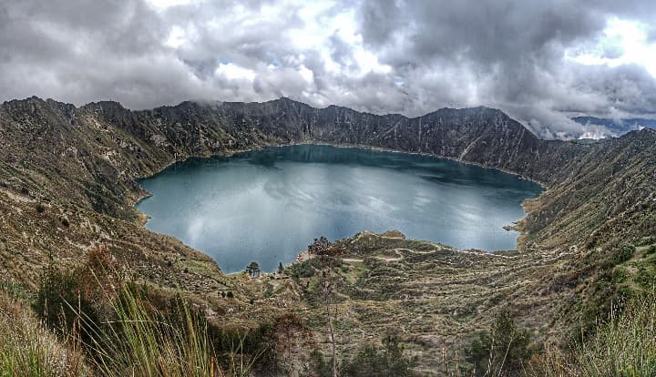 lago Quilotoa rodeado de montañas, cielo gris - weroad
