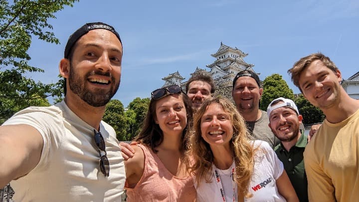 selfie de viajeros weroad con detrás un edificio japonñes y arboles