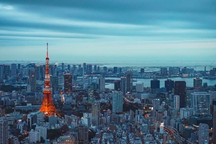 vista de la ciudad del barrio de minato en tokio, japon, se aprcia una torre roja y rascacielos azulados - weroad