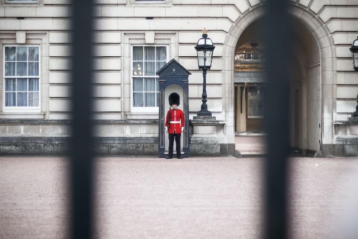 guardia en buckingam palace, visto desde reja, algo que ver en londres
