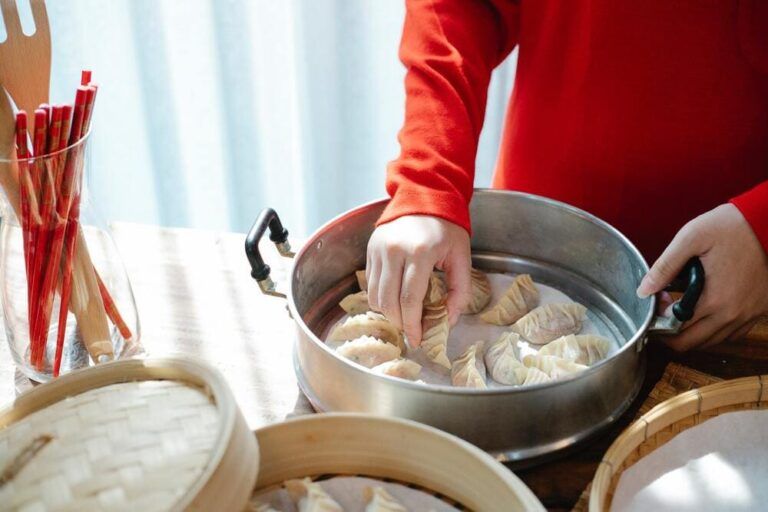 persona poniendo gyozas, comida típica de japón, en una olla - weroad