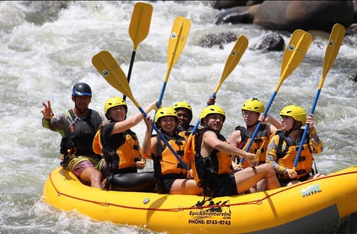 viajeros de grupo weroad haciendo rafting en un bote amarillo 