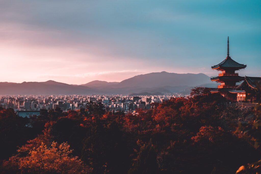 vista de una ciudad de japón con edificios típicos y arboles de color naranja, en otoño - weroad