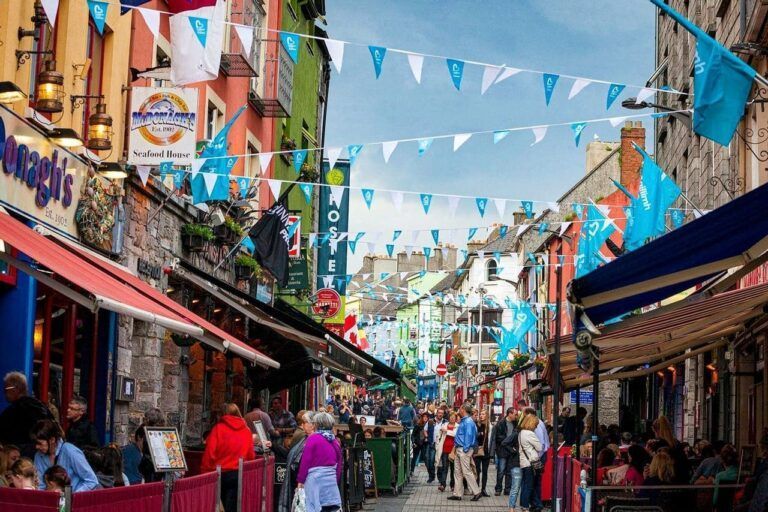 calle con tiendas y edificios coloridos y banderitas colgadas entre las fachadas en galway, destino que ver en irlanda