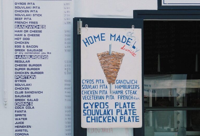 cartel del restaurante en grecia con dibujado un kebab y listados platos y precios