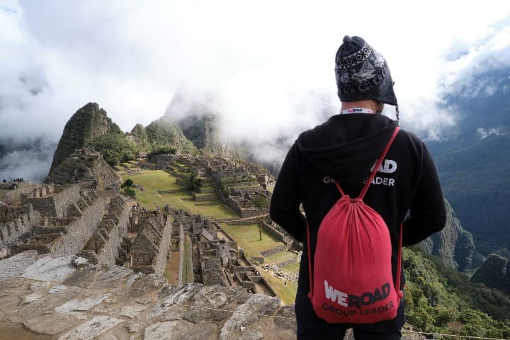 viajero weroad de espaldas con mochila y mirando hacia machu picchu