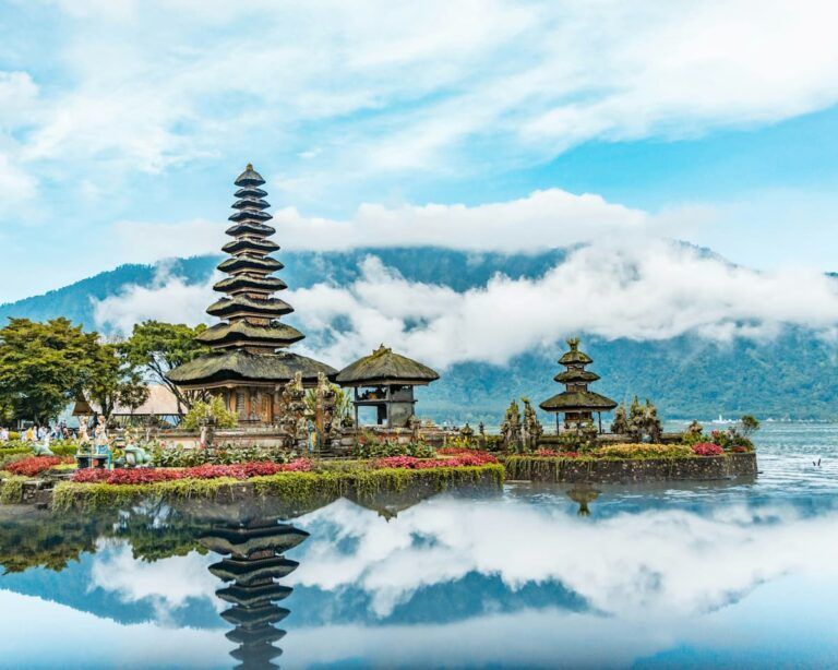 templo en bali con agua alrededor y montañas al fondo. es un buen destino para vivir un año nuevo en el mundo distinto