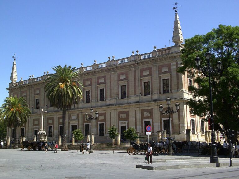 edificio del archivo general de indias con palmeras delante, algo que ver en sevilla